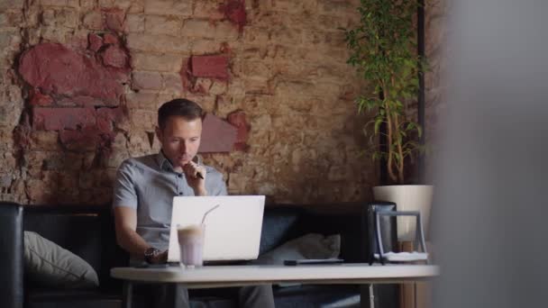 Pensativo sério jovem estudante escritor sentar-se em casa mesa de escritório com laptop pensando em inspiração solução problema ideias perdidas em pensamentos conceito sonhando olhando para longe — Vídeo de Stock