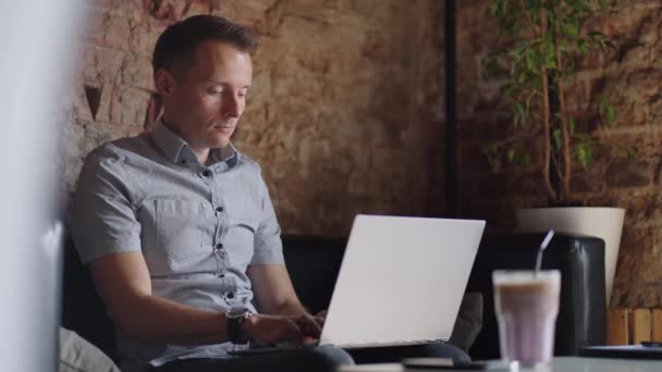 Pengembang laki-laki atau mahasiswa yang indah bekerja, belajar dengan laptop di kafe. freelance, pekerjaan jarak jauh, pendidikan online, bekerja sendiri — Stok Video