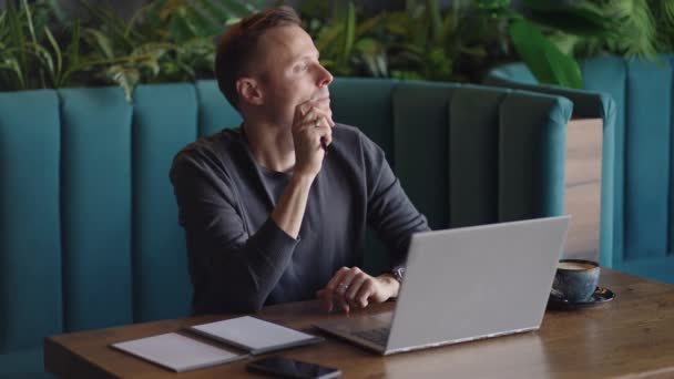 Thoughtful serious young man student writer sit at home office desk with laptop thinking of inspiration search problem solution ideas lost in thoughts concept dreaming looking away — Stock Video