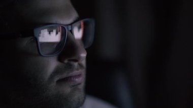 Borsada işlem yapan bir simsarın siyah gözlüklerinde, bir Forex 'te üzerinde göstergeler olan bir tablo yansıtılır. Veriler analiz ediliyor. Ekran yansımaları grafiği. Yatırım yapmak için borsa