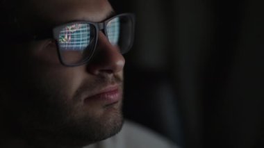 Borsada işlem yapan bir simsarın siyah gözlüklerinde, bir Forex 'te üzerinde göstergeler olan bir tablo yansıtılır. Veriler analiz ediliyor. Ekran yansımaları grafiği. Yatırım yapmak için borsa