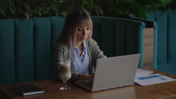 Junge attraktive asiatische Büroangestellte sitzt am Laptop am Schreibtisch, arbeitet und denkt. — Stockvideo