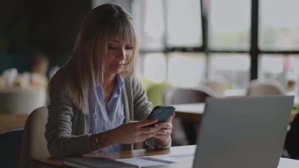 Jovem menina asiática usando seu smartphone olhando ao redor com um sorriso. Dispositivos modernos, gadgets, vício, estar online. Redes sociais. Chinês mulher ler mensagem no sorriso smartphone — Vídeo de Stock