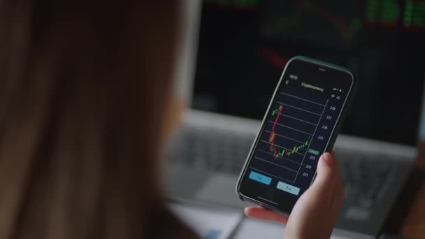 Investeerder controleren van beursgegevens op het scherm Mobiele telefoon. Aziatische vrouw de handel in aandelen markt op smart phone met aandelenmarkt financieel scherm. cryptogeld prijs grafiek op een van een smartphone scherm — Stockvideo