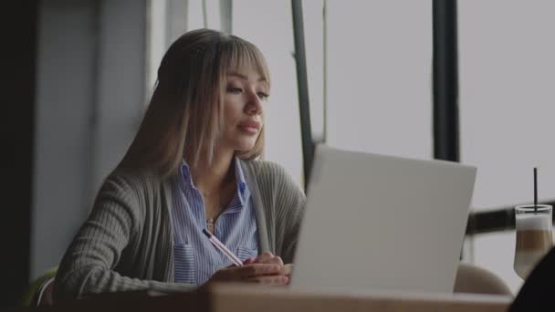 Nachdenkliche besorgte Chinesin, Japanerin, Japanerin, Koreanerin, die am Laptop arbeitet, wegschaut und denkt, Problem löst, ernsthafte Frau auf der Suche nach Inspiration macht Entscheidung ideenlos — Stockvideo