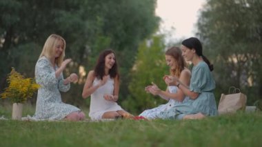 Açık havada bir grup genç kız kil modelliğinde usta bir sınıf yönetiyor. Ortak faaliyet, iletişim, kahkaha, ortak hobi, kadın çemberi, yaratıcı faaliyetler.