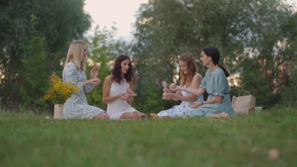 Un gruppo di giovani donne in natura, nel parco, tengono un master class in modellazione dell'argilla. Attività congiunta, comunicazione, risate, hobby comune, cerchio delle donne, attività creative. — Video Stock