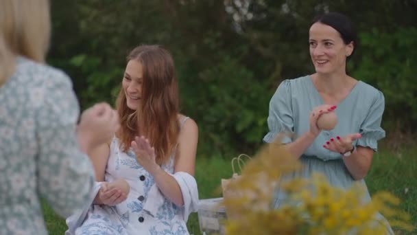 Un grupo de mujeres jóvenes esculpe de arcilla en la naturaleza, en un parque, en un espacio abierto. Las chicas se dedican a la artesanía, creatividad juntos, comunicarse, sonreír, hablar, disfrutar del proceso. — Vídeos de Stock