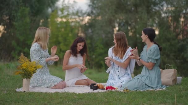 Un groupe de jeunes femmes dans la nature sculptent ensemble à partir d'argile. Classe ouverte, activité conjointe, communication, rire, passe-temps commun, cercle de femmes. — Video