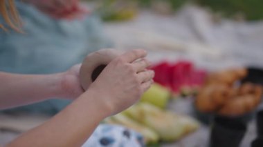 Kadınlar açık bir alanda kilden heykel yaparlar. Bir grup kız, kil modellik eğitimi, hobiler, yaratıcılık, el yapımı işler. Ürünün yakın planda modellenmesi.