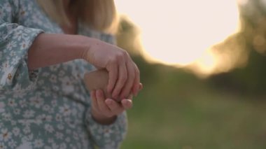 Kadınların elleri doğada, açık havada, akşamleyin parkta, gün batımında kilden bir nesne yontuyor..