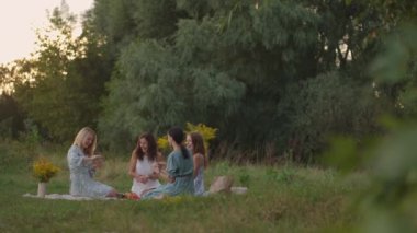 Doğadaki bir grup çekici kadın, parkta, kil modelliği üzerine bir master sınıfı yönetiyor. Ortak aktivite, iletişim, kahkaha, ortak hobi, kadın çemberi, yaratıcı aktivite.