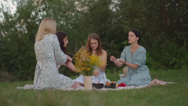 Un grupo de mujeres jóvenes están esculpiendo de arcilla, escuchando al maestro, comunicándose, en el campo, al aire libre. El maestro explica la técnica correcta de escultura. Actividades creativas, hobby. — Vídeos de Stock