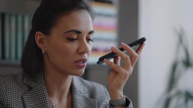 Genç İspanyol, elinde bir cihaz tutan Arap bir kadın sesli mesaj bırakın sesli mesaj bırakın akıllı telefon cihazında hoparlör kullanın, cep telefonu uygulamasını paylaşın. Sesli mesaj gönderiliyor