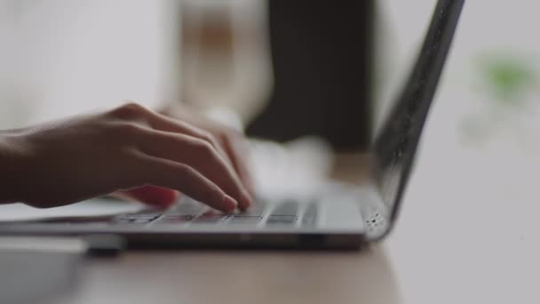 Eine junge Frau tippt in Großaufnahme auf der Tastatur eines Laptops, der zu Hause sitzt. Fernbedienung von zu Hause aus. Innenministerium — Stockvideo