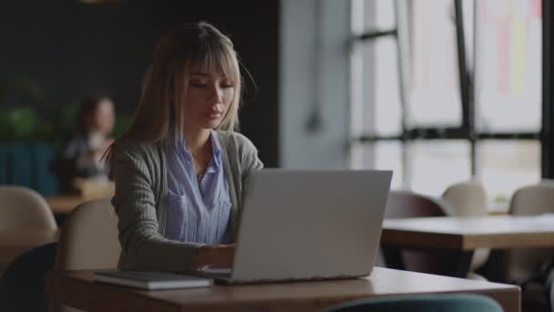 Online werken op de laptop van een Aziatische vrouw op de campus — Stockvideo