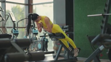 Genç ve güzel İspanyol kadın spor salonunda hiperuzatma yapıyor. Kararlı kadın spor salonunda yedek kulübesinde uzantısını yapıyor. Yoğun erkeksi enerji. Sağlıklı bir yaşam tarzı. Spor konsepti