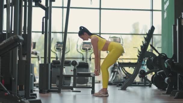 ヒスパニック系の女性の行の上に曲げバーベルを実行します。フィットネス女子トレーニングベントオーバーロウ中出しベントオーバーロウ中出しバーベルロウ。傾斜に立っている間、あなたの背中の筋肉を鈴で訓練します。 — ストック動画