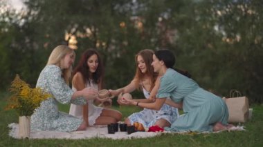 Doğadaki bir grup çekici kadın, açık bir alanda, kilden heykel yapıp, dersin sonuçlarını tartışıyor, iletişim kuruyor, etkilerini paylaşıyor, gülüyor, sonuçlara seviniyor..