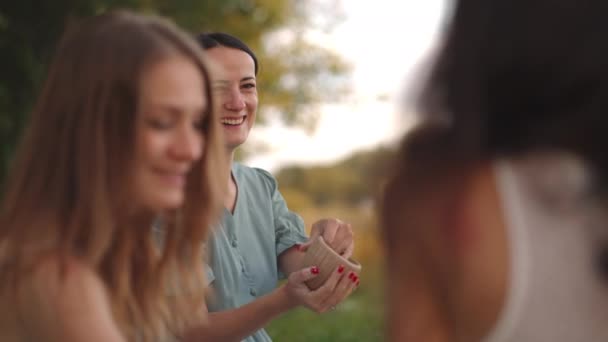 Jóvenes mujeres atractivas en la naturaleza, áreas abiertas se dedican a modelar a partir de arcilla, dar forma a los productos, comunicarse, compartir impresiones, reír, dar consejos, recomendaciones entre sí. — Vídeo de stock