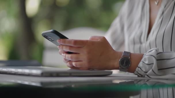 Primer plano de una mujer escribiendo en la pantalla de un teléfono móvil mientras está sentado en un café de verano. Banca por Internet, navegación por sitios móviles — Vídeos de Stock