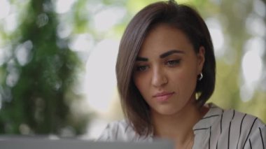 Ciddi bir kadın portresi, Arap kökenli esmer Latin kökenli bir grup, bir yaz kafesinde dizüstü bilgisayarla bir masada oturuyor. Klavyedeki yazılar internet üzerinden eğitim görüyor, bir internet bankası satın alıyor ve onunla anlaşıyor