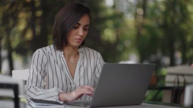 Ciddi bir kadın portresi, Arap kökenli esmer Latin kökenli bir grup, bir yaz kafesinde dizüstü bilgisayarla bir masada oturuyor. Klavyedeki yazılar internet üzerinden eğitim görüyor, bir internet bankası satın alıyor ve onunla anlaşıyor