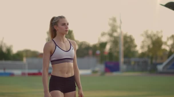 Female athlete starting her sprint on a running track. Runner taking off from the starting blocks on running track. Young woman athlete start running from block. Slow motion, — Stock Video