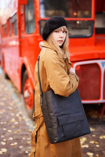 Blond Vrouwtje Zwarte Baret Oranje Jas Straat Met Dubbeldekker Achtergrond — Stockfoto
