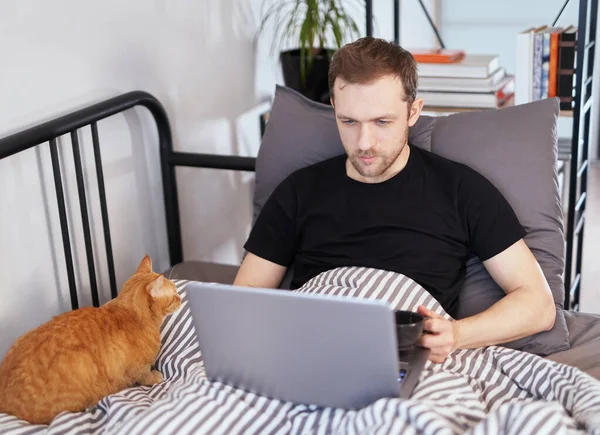 Giovane Uomo Shirt Nera Sdraiato Letto Con Laptop Tazza Caffè — Foto Stock