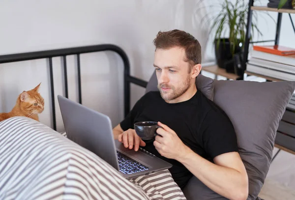 Attraente Uomo Barbuto Seduto Letto Ufficio Con Tazza Bevanda Calda — Foto Stock