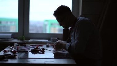 Stüdyoda çalışan profesyonel bir sanatçının silueti. Profesyonel bir taşbaskı ustasının üretim yaptığı yerde. 4k görüntü