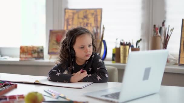 Стиль Електронного Навчання Маленької Дівчинки Малюк Навушниками Ноутбуком Сидить Столом — стокове відео