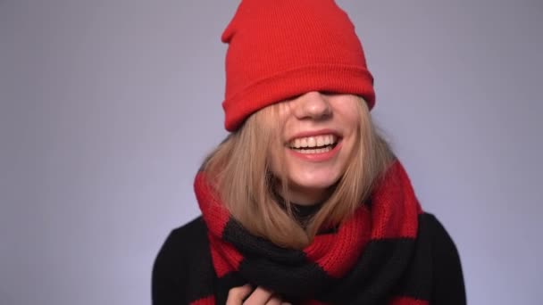 Atrakcyjne blondynka dziewczyna śmieje się w czerwony czapka kapelusz na oczy — Wideo stockowe