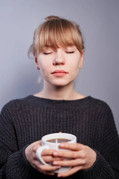 Menina sonhando com xícara de bebida quente e olhos fechados — Fotografia de Stock