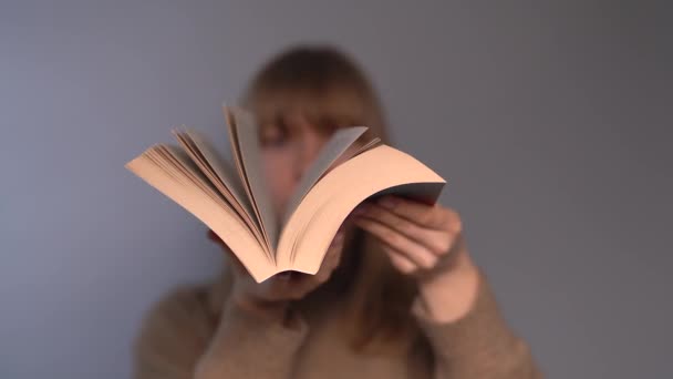 Educatief concept. jong meisje bladeren door een open boek — Stockvideo