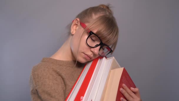 Słodkie zmęczony nerd student dziewczyna w okulary z stos książek — Wideo stockowe