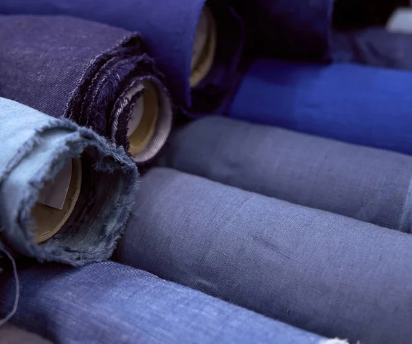 Colorful textile rolls in shop in blue and gray colors