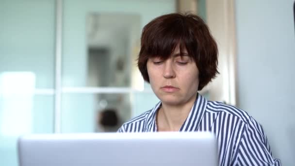 Brünette Frau tippt auf Laptop im Home Office — Stockvideo