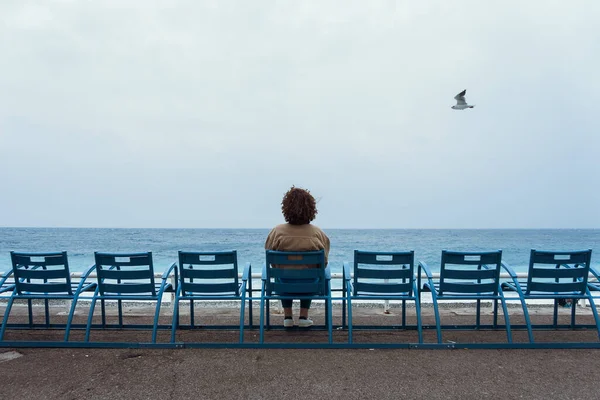 Женщина сидит на синих стульях в Ницце, Лазурный Берег, Франция — стоковое фото