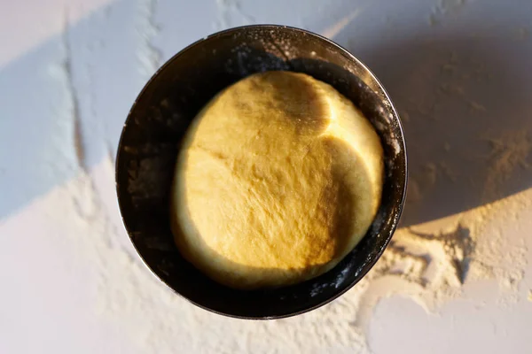 Dough proofing in metal bowl with sunset sunlight — Stock Photo, Image