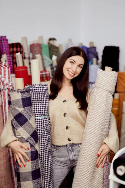 Smiling woman designer or tailor standing with textile rolls — Stock Photo, Image