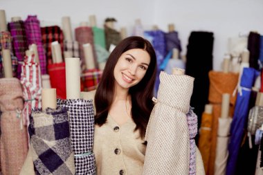 Çekici gülümseyen terzi ya da terzi tekstil rulolarına sarılır