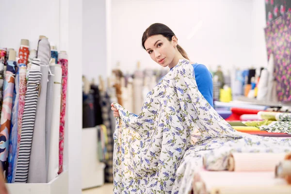 Loja de cortinas cliente mulher aplicando pano têxtil em si mesma — Fotografia de Stock