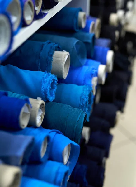 Rollos de tela textil en colores azul y negro en atelier — Foto de Stock