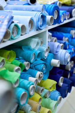 Atölyede mavi, sarı ve yeşil renkli tekstil ruloları