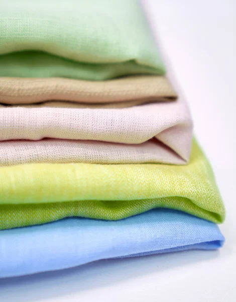 Toallas de tela de lino multicolor en pila sobre mesa blanca —  Fotos de Stock