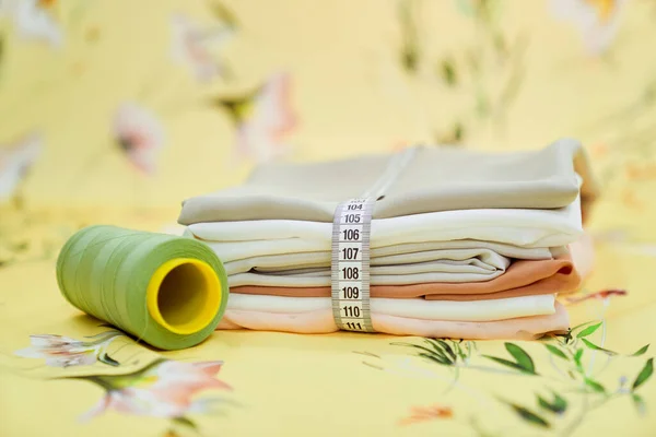 Weefsels verpakt als geschenk met maatband en naaigarens — Stockfoto