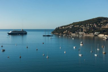 Yolcu gemisi ve küçük köylü lüks tekneleri olan bir deniz.