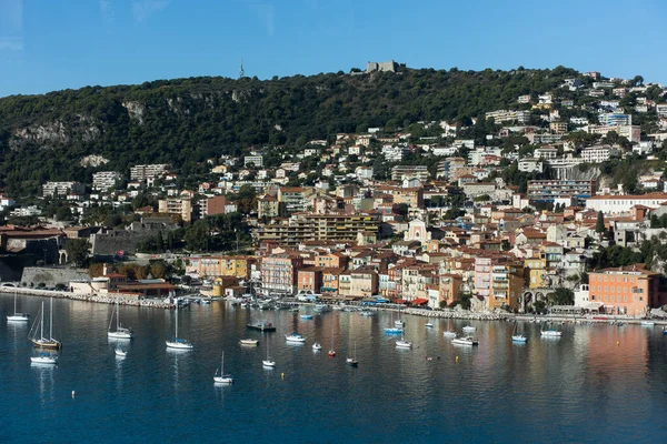 Mar com barcos e pequena aldeia em uma colina na riviera francesa — Fotografia de Stock